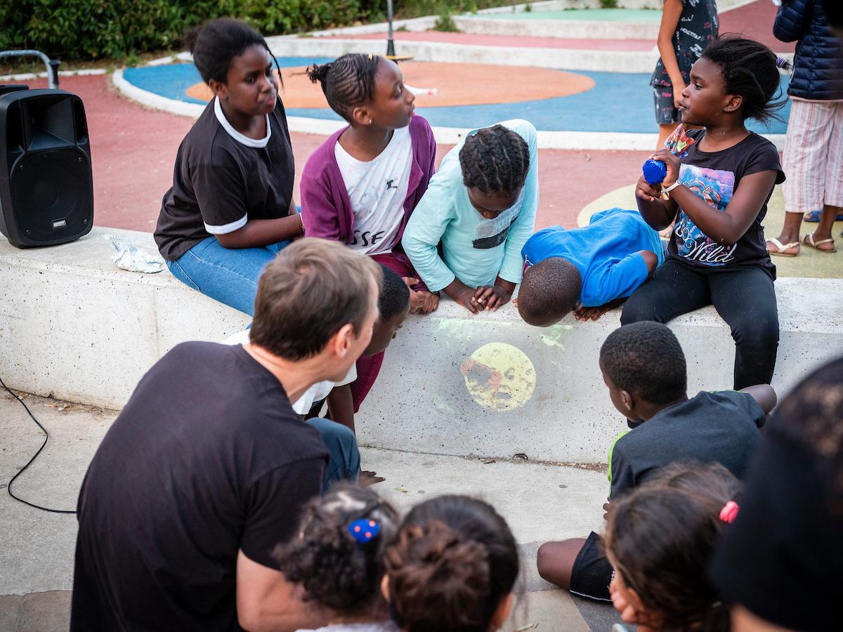 Groupe d'enfant qui assiste à la projection sur un muret